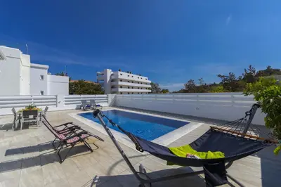 a hammock on the roof of a house with a pool at Protaras Villa Araella in Ayia Napa