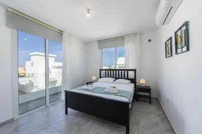 a bedroom with a bed and a large window at Protaras Villa Araella in Ayia Napa