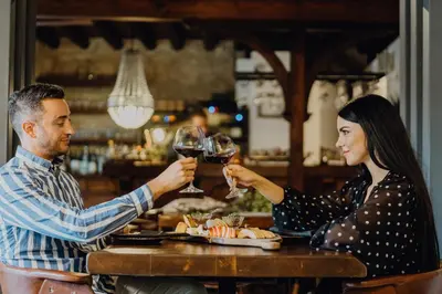a man and woman sitting at a table drinking wine at Oinou Strata - Adults Only in Vouni