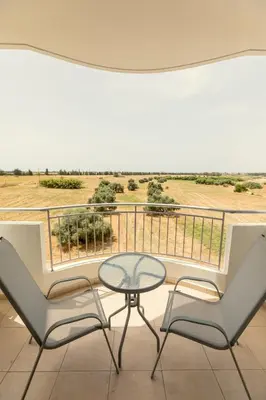 a table and two chairs on a balcony with a view at Oceania Bay Village in Pyla