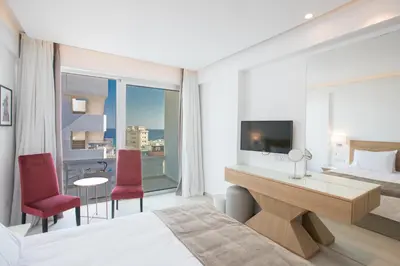 a hotel room with a bed and a desk with a television at Kokkinos Boutique Hotel in Protaras