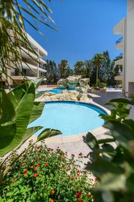 a swimming pool in a resort with a fountain at Mediterranean Sunrise Complex in Voroklini