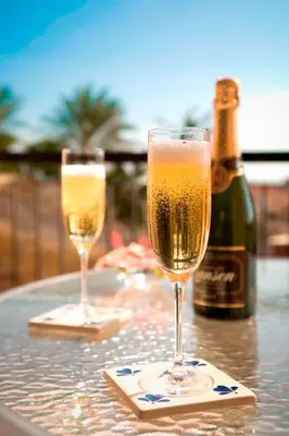 two glasses of champagne on a table with a bottle of wine at Mediterranean Sunrise Complex in Voroklini