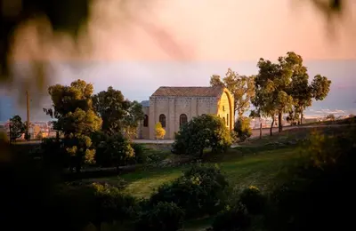 a church on a field with trees in front of it at Mediterranean Sunrise Complex in Voroklini