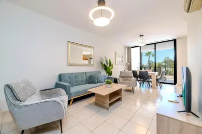 a living room with a couch and chairs and a tv at Mediterranean Sunrise Complex in Voroklini
