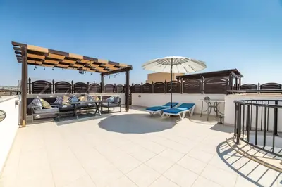 a patio with furniture and an umbrella on a roof at Blue Serenity Complex in Larnaka