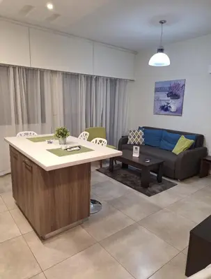 a living room with a couch and a table at By The Way Apartment in Larnaka