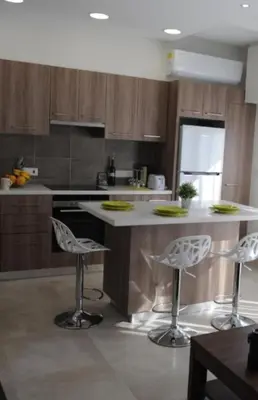a kitchen with a counter and stools in it at By The Way Apartment in Larnaka