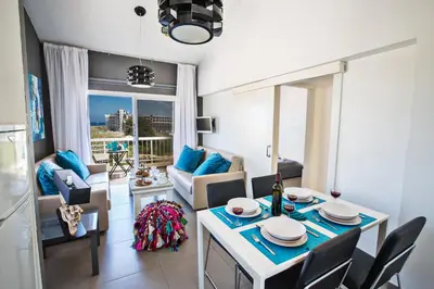 a kitchen and living room with a table and chairs at Nicholas Seaview Apartments in Protaras