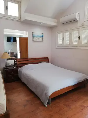 a bedroom with a large bed and a desk at Swallows Nest in Larnaka