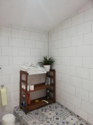 a bathroom with a toilet and white tiled walls at Swallows Nest in Larnaka