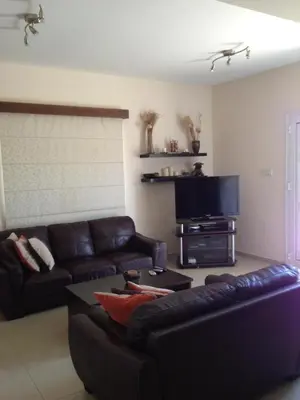 a living room with a couch and a flat screen tv at Maricosta Villas in Protaras