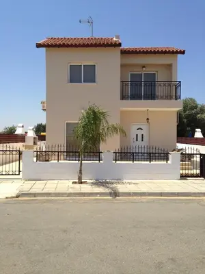 a white house with a palm tree in front of it at Maricosta Villas in Protaras
