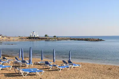 a group of chairs and umbrellas on a beach at Maricosta Villas in Protaras