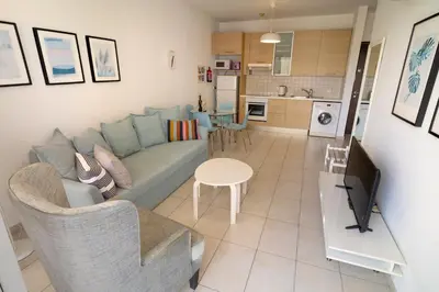 a living room with a couch and a table at Blue Dawn Center Flat in Larnaka