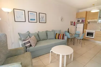 a living room with a couch and a table at Blue Dawn Center Flat in Larnaka