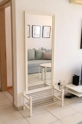 a large mirror in a room with a couch at Blue Dawn Center Flat in Larnaka