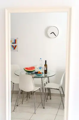 a dining room table with white chairs and a plate of food at Violet Dusk City Center Flat in Larnaka