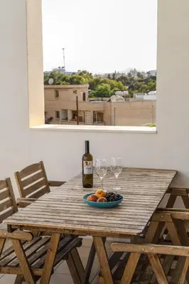 a wooden table with a bottle of wine and glasses at Violet Dusk City Center Flat in Larnaka