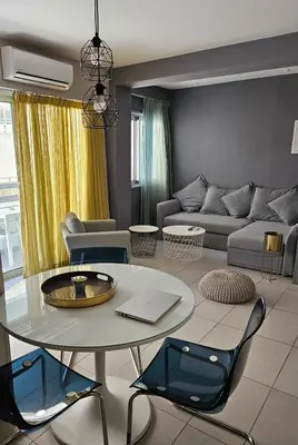 a living room with a table and a couch at Beachfront Amazing New Apartment in Limassol