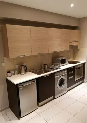 a kitchen with a sink and a washing machine at Beachfront Amazing New Apartment in Limassol