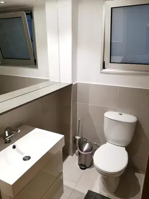 a bathroom with a toilet and a sink and a window at Beachfront Amazing New Apartment in Limassol