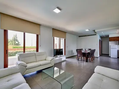 a living room with white couches and a dining room at Angie Luxury Beach Villas in Ayia Napa