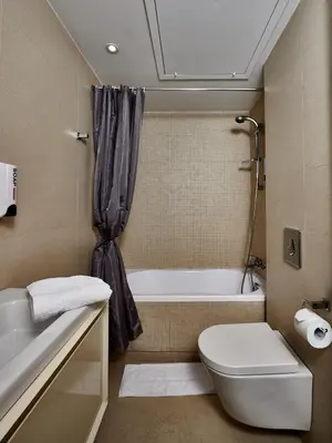 a bathroom with a tub and a toilet and a sink at Angie Luxury Beach Villas in Ayia Napa