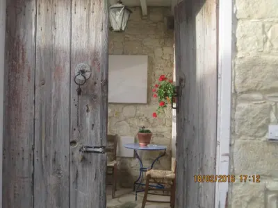 a wooden door leading to a table with a plant at Oinochori in Vouni