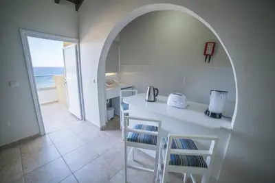 a kitchen with a table and chairs with a view of the ocean at MyroAndrou Beach Hotel Apartments in Protaras