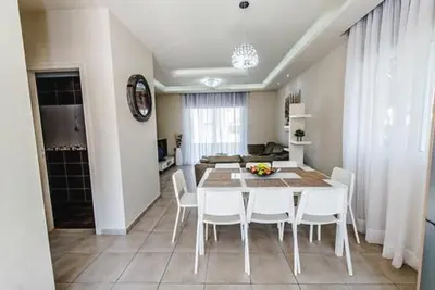 a dining room with a table and white chairs at Timotheos Villa in Protaras