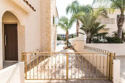 a staircase leading to a building with palm trees at Timotheos Villa in Protaras