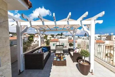 a white pergola on top of a balcony at Timotheos Villa in Protaras