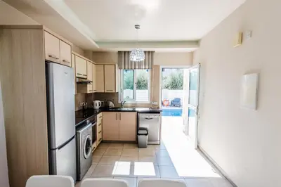 a kitchen with a refrigerator and a sink at Timotheos Villa in Protaras