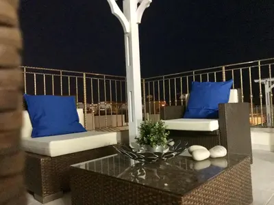 a balcony with two chairs and a table with blue pillows at Timotheos Villa in Protaras