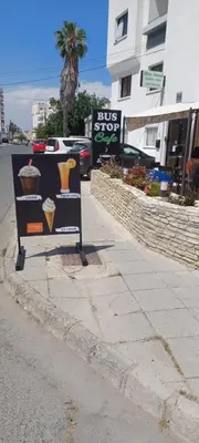 a bus stop sign on the side of a street at Olive Island in Larnaka