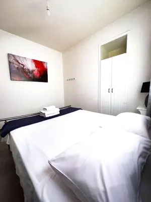 a bedroom with a white bed and a painting on the wall at Olive Island in Larnaka
