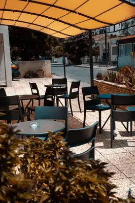 a group of tables and chairs under an umbrella at Olive Island in Larnaka