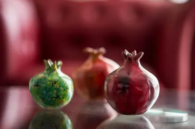 a group of three pomegranates sitting on a table at Mesogios House Suites in Larnaka