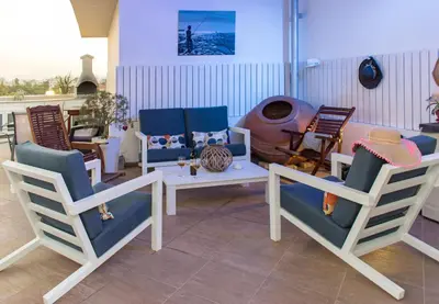 a living room with chairs and a table and a couch at Mesogios House Suites in Larnaka