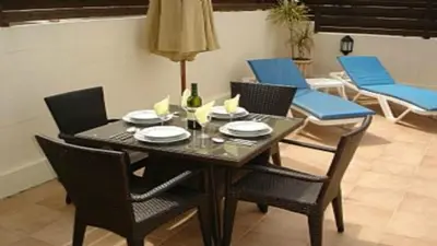 a dining room table with chairs and a table with plates and wine glasses at Villa Emiliana in Paralimni