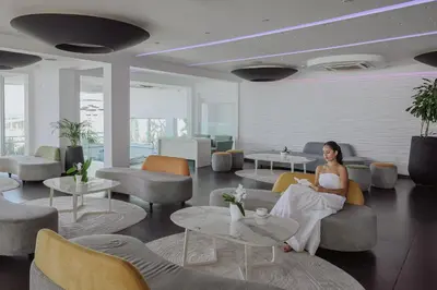 a woman sitting on a couch in a lobby at Tasia Maris Oasis in Ayia Napa