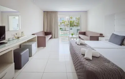 a hotel room with a bed and a living room at Tasia Maris Oasis in Ayia Napa