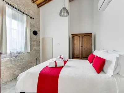 a bedroom with a large white bed with red pillows at Arsorama Village Homes in Arsos