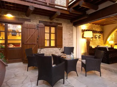 a patio with chairs and a table and a building at Arsorama Village Homes in Arsos