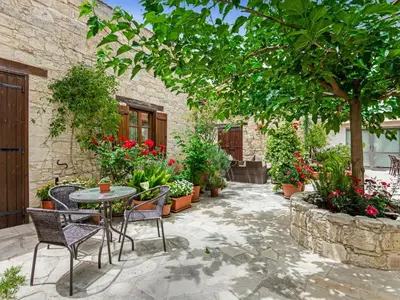 a patio with a table and chairs and plants at Arsorama Village Homes in Arsos