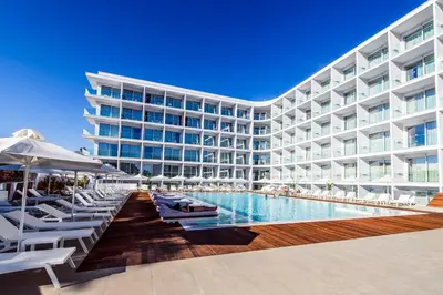 a large building with a swimming pool and lounge chairs at Eleana Hotel in Ayia Napa