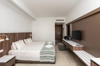 a hotel room with a bed and a flat screen tv at Eleana Hotel in Ayia Napa
