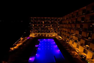a pool in the middle of a hotel at night at Eleana Hotel in Ayia Napa
