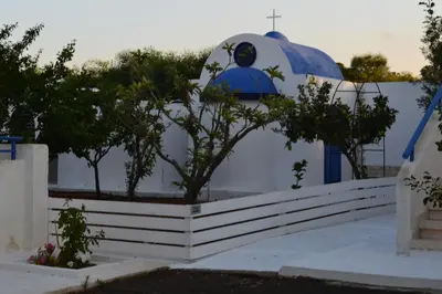 a white and blue building with a dome and trees at Flokkas Hotel Apartments in Protaras